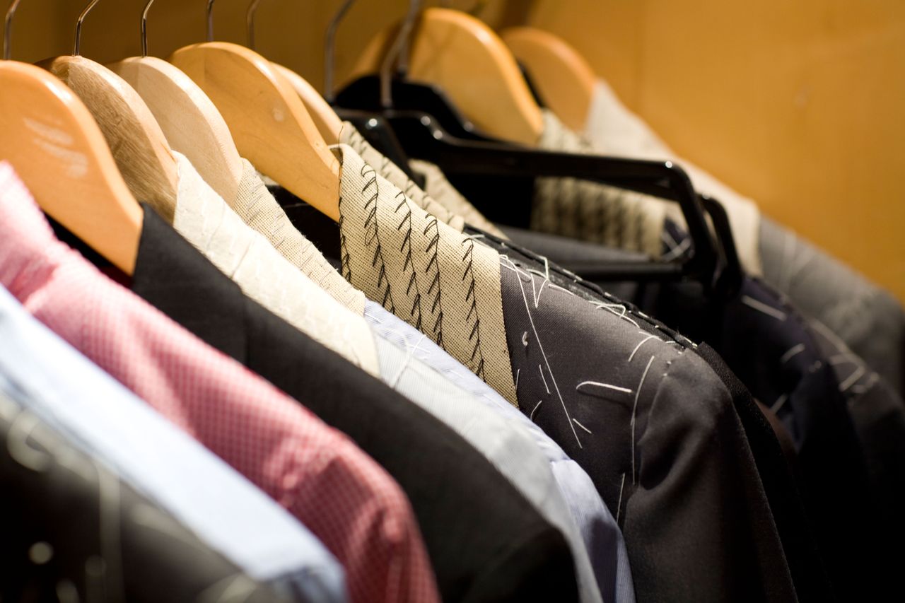 Tailored suits hang up in a tailor store.