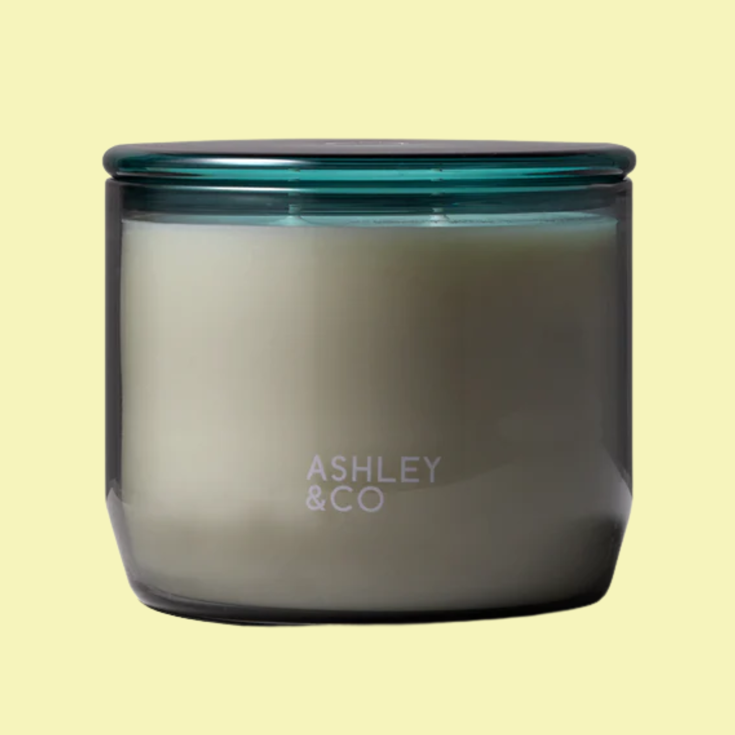 A scented candle in a blue glass jar with a lid