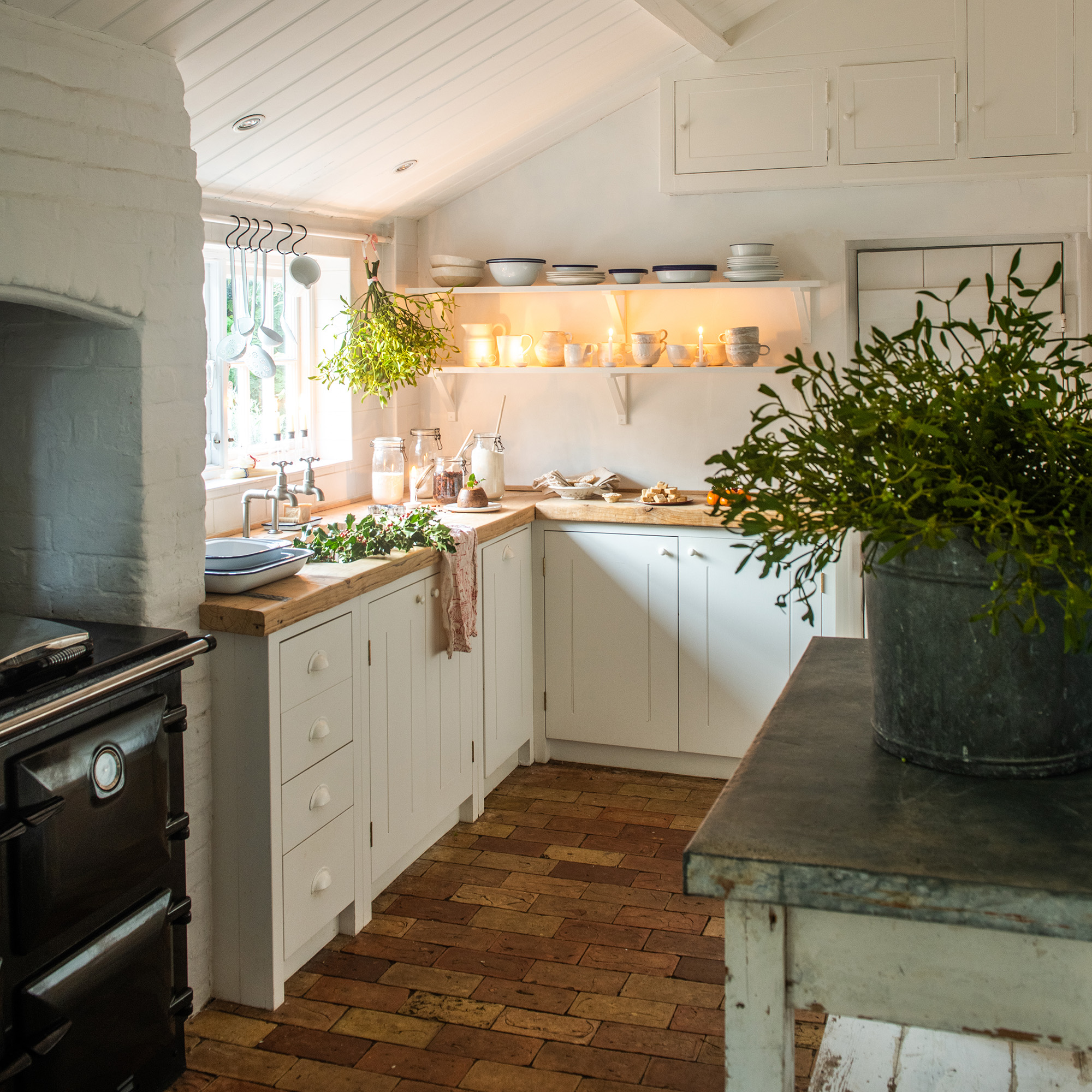 neutral kitchen with cream cabinets and wooden worktops dressed for christmas with mistletoe and festive foliage 1