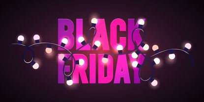 The words "Black Friday" in pink block letters behind a string of festive lights.