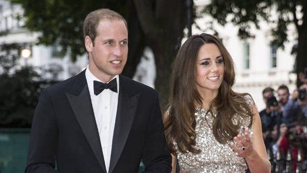 Prince William wearing tux & Kate Middleton wearing evening gown, walking on the red carpet