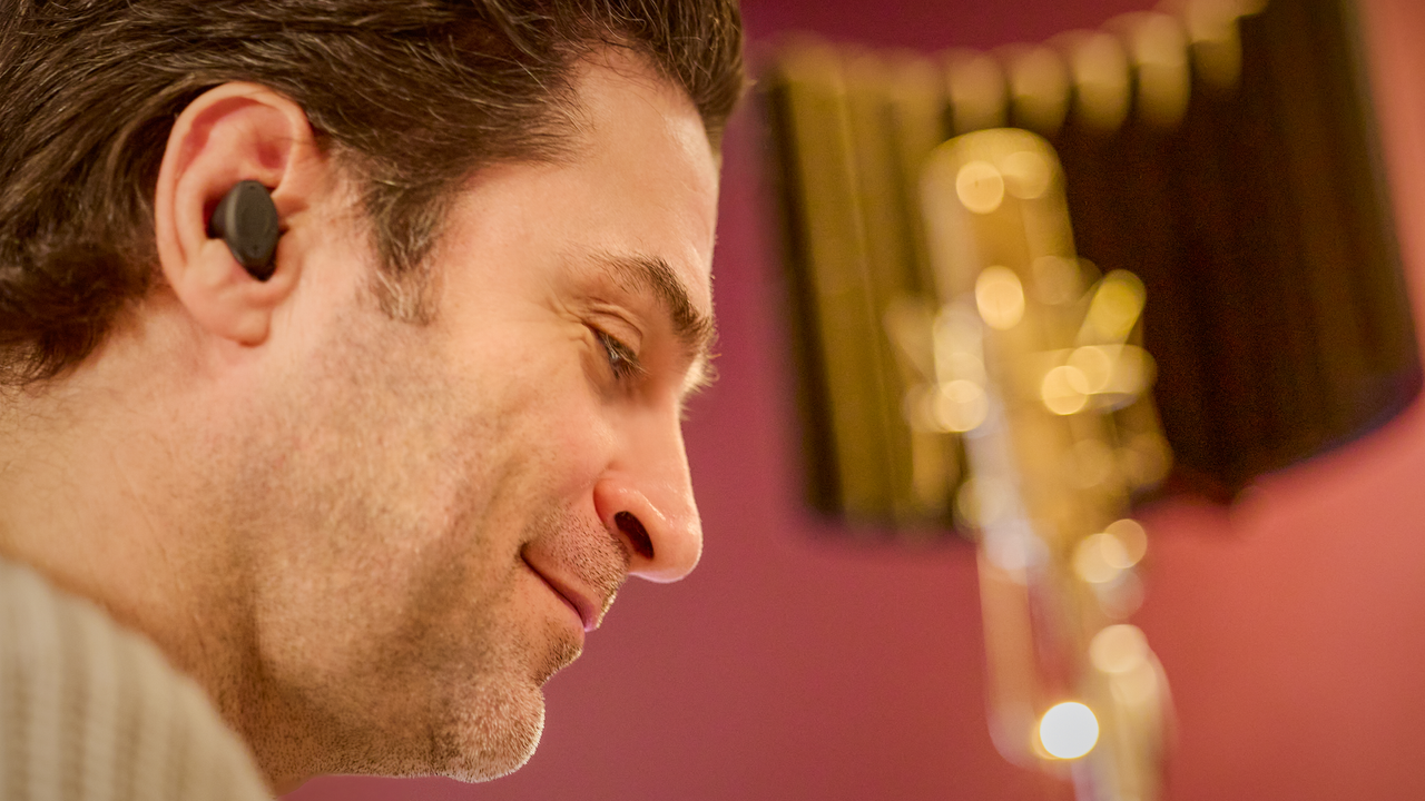 A smiling man wearing Breggz Zohn-1 earphones