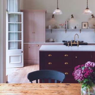 Harvey Jones traditional kitchen with dark red island and light pink cabinetry