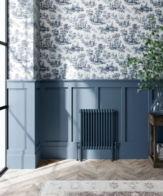 Blue column radiator against blue panelling and blue patterned wallpaper