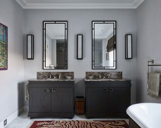 Grey painted bathroom with twin sinks and twin mirrors, marble countertop
