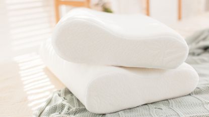 Memory foam pillows stacked on top of green blanket