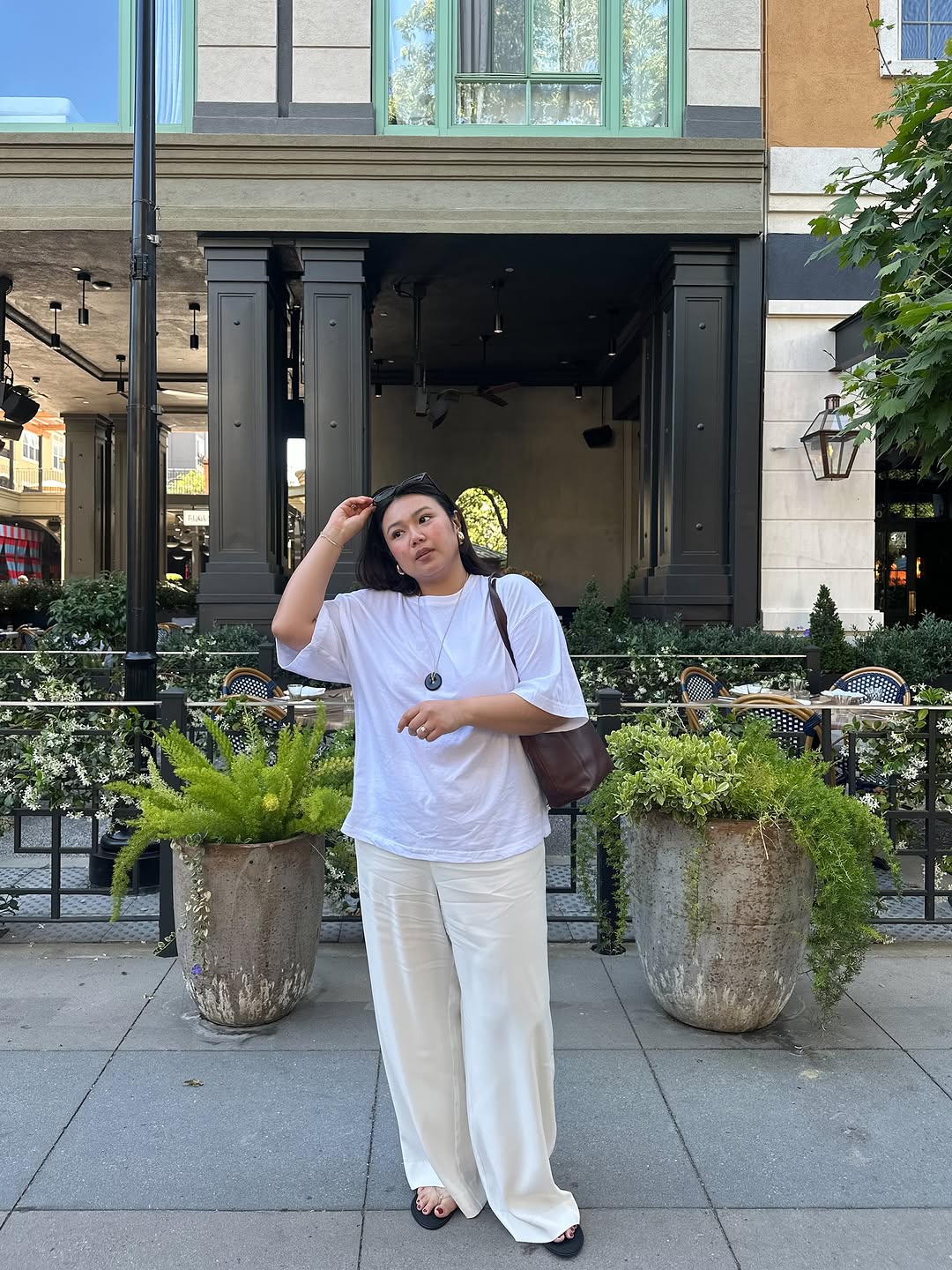 woman wearing long cord necklace with t-shirt and pants summer 2025