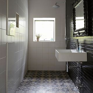 bathroom with white tiled walls and white washbasin