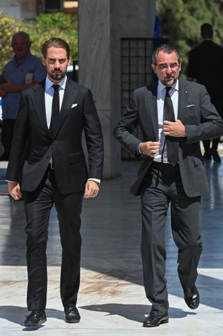 Prince Philippos of Greece and Prince Nikolaos of Greece in black suits attending the funeral of Prince Michael of Greece at the First Cemetery of Athens