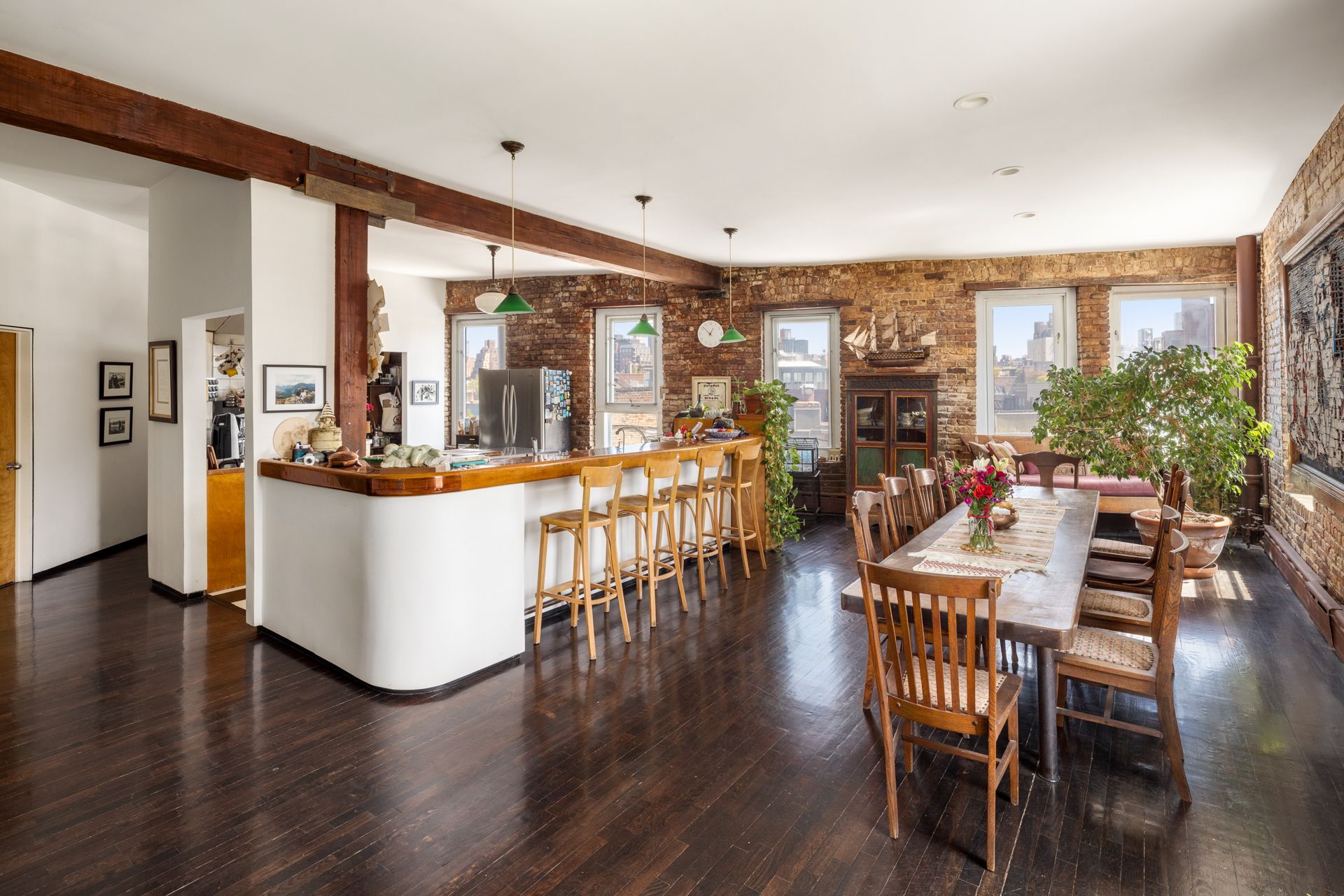 Details of the penthouse at 719 Greenwich Street, showing a characterful home with lots of wood, exposed brick, and fabulous views