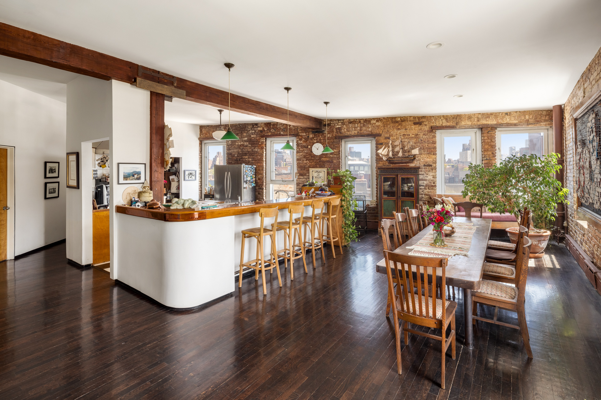 Details of the penthouse at 719 Greenwich Street, showing a characterful home with lots of wood, exposed brick, and fabulous views