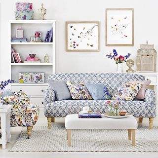 living room with white wall and sofa with cushions and folksy print