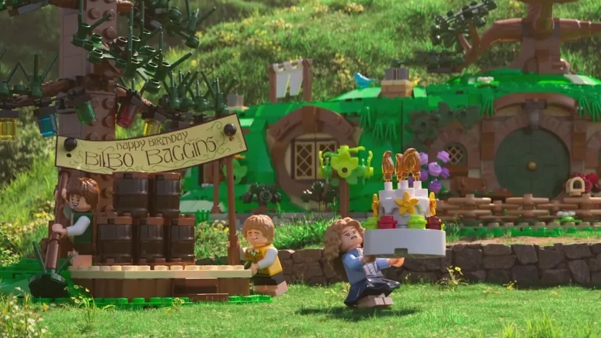 Bilbo Baggins birthday recreated in LEGO with a woman carrying a cake whilst other mini LEGO figures put up a sign