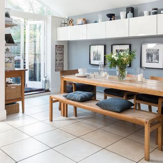 dining area with white wall and wooden dining table and glass door