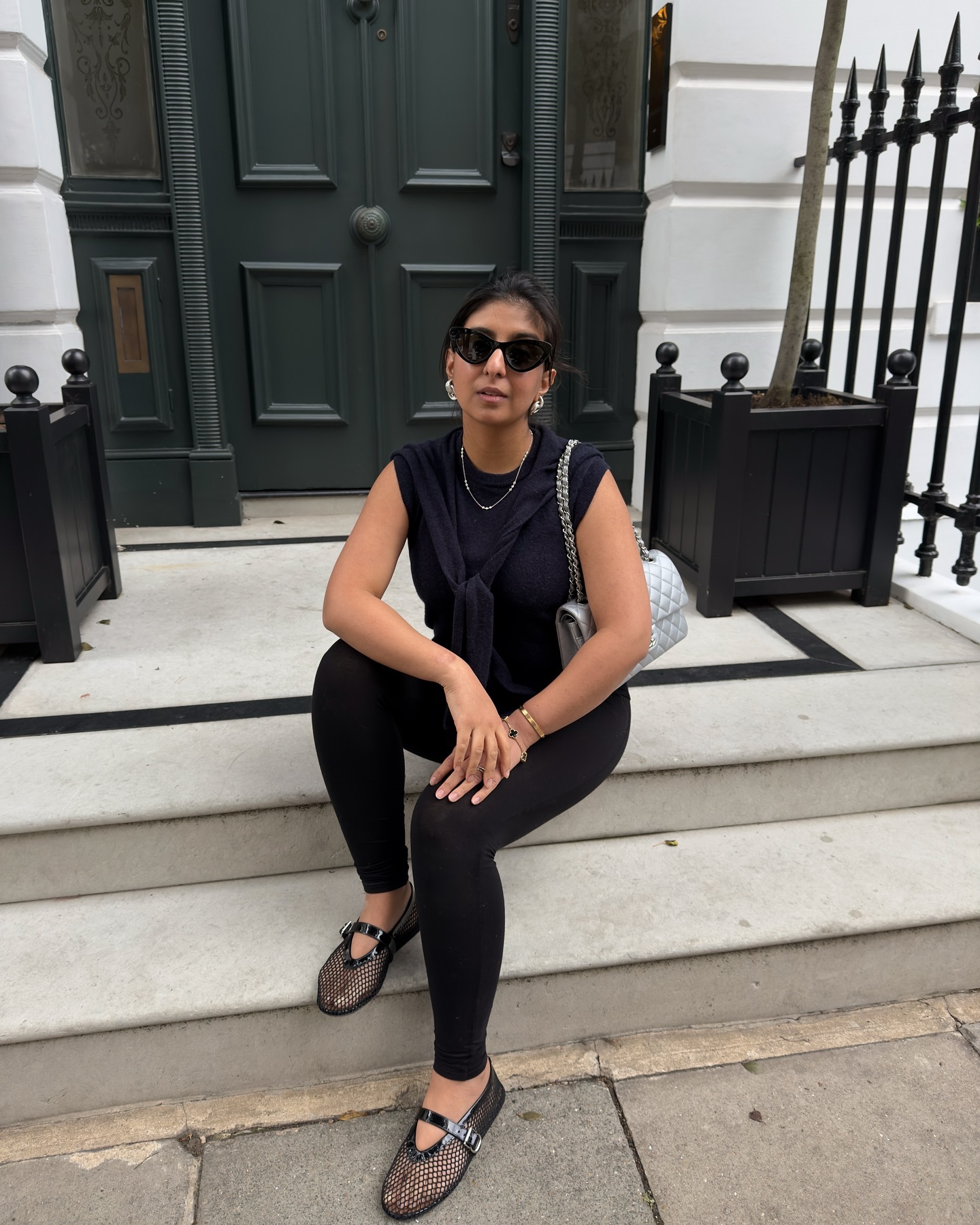 An image of @shloka wearing a fine knit top with built-in tie up detail with leggings and mesh flats.