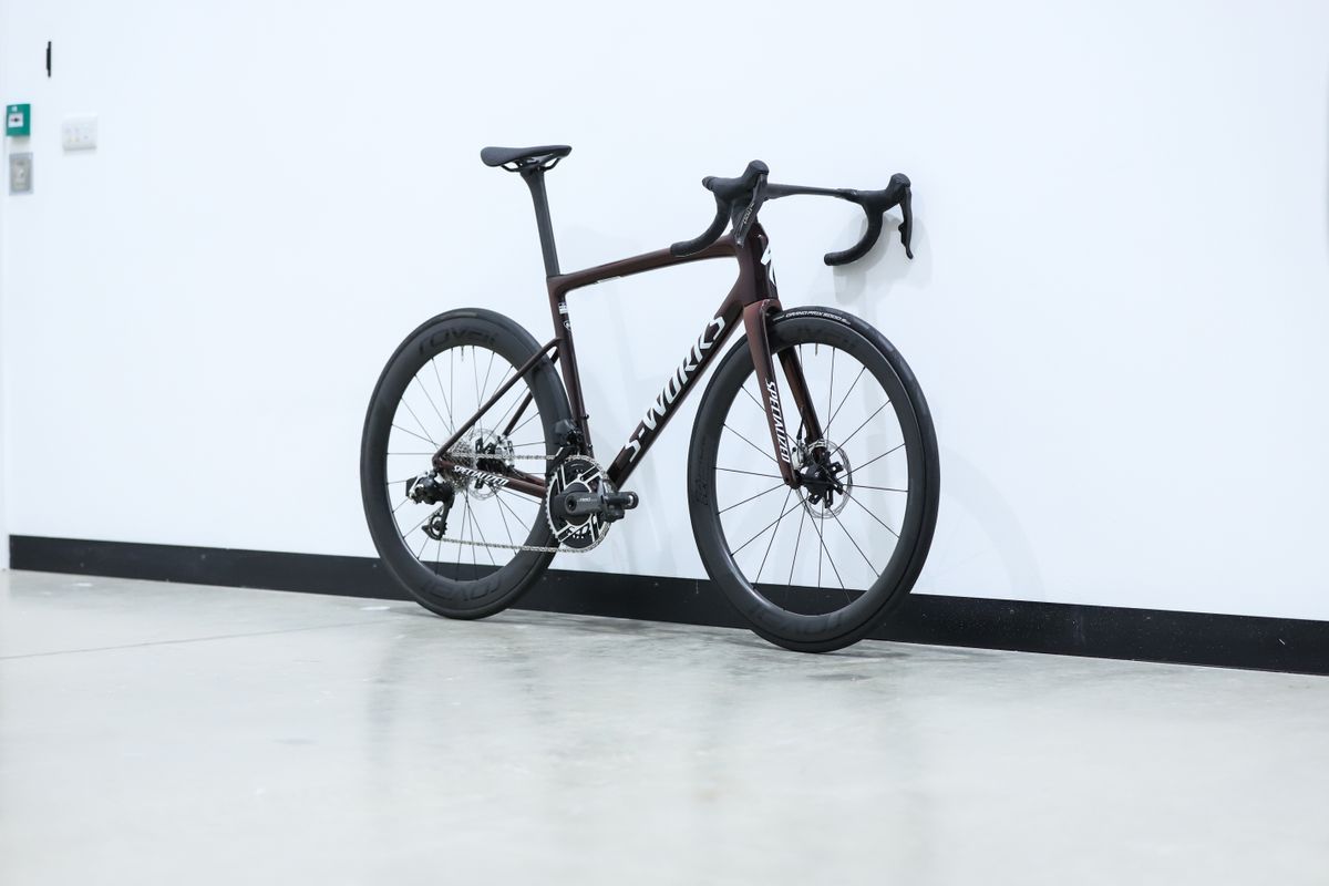 A red S-Works Tarmac SL8 stands against a white wall