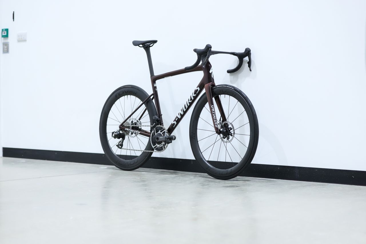 A red S-Works Tarmac SL8 stands against a white wall