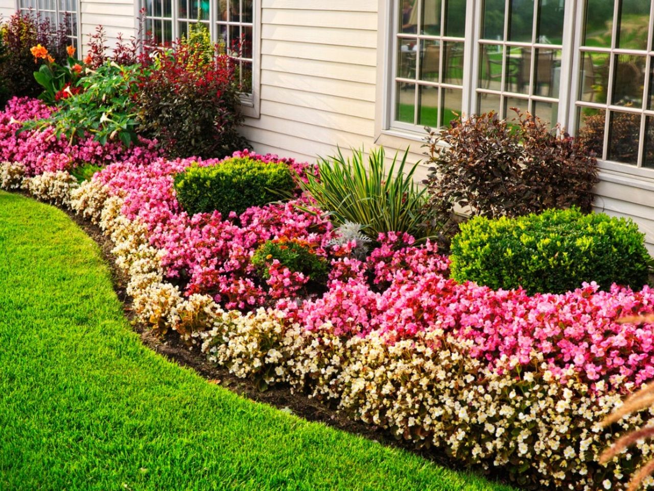 A Sunken Garden Bed Full Of Colorful Flowers And Plants