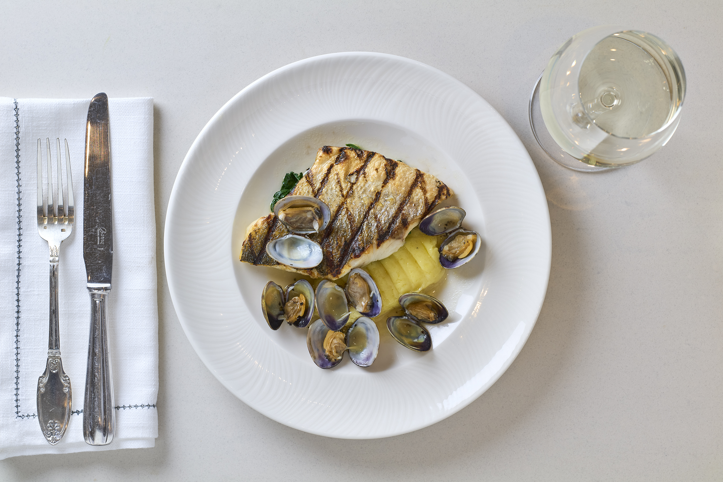 Sea bass fillet, Scottish clams, saut&amp;eacute;ed spinach, potato &amp;amp; celeriac mash, white wine at Tortello restaurant, Royal Lancaster hotel, London