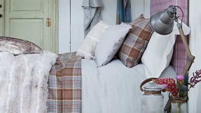 Tartan bedsheets in rustic looking bedroom