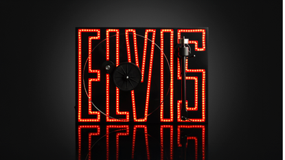 Pro-Ject Elvis Turntable on a black background with the ELVIS logo illuminated in red and orange