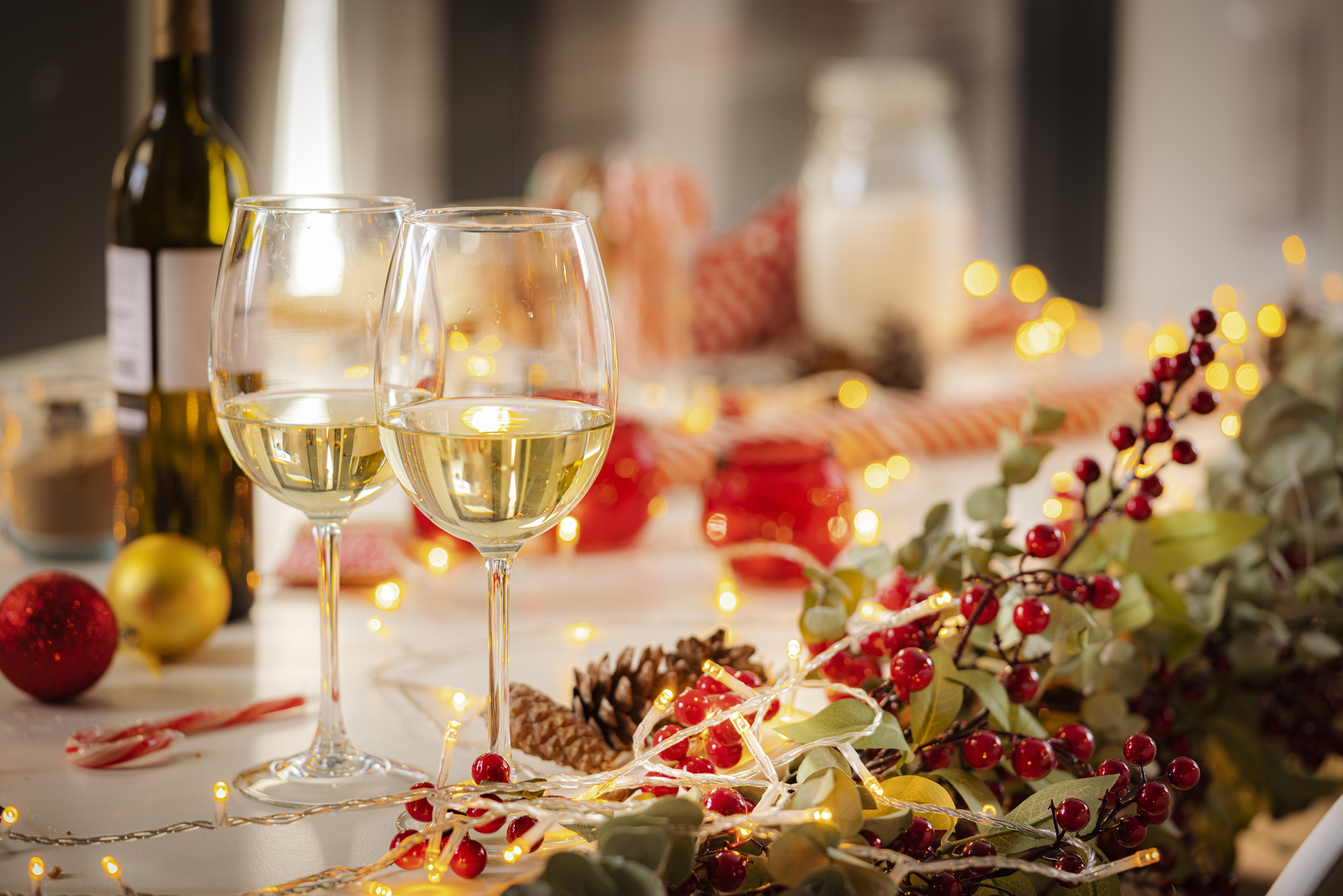 Two white wine glasses on Christmas table.