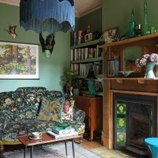 vintage style living room with patterned sofa, edwardian fireplace and green blue walls