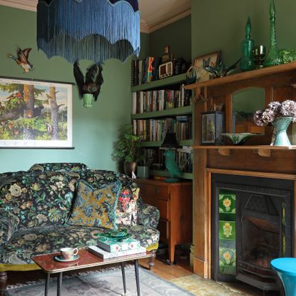 vintage style living room with patterned sofa, edwardian fireplace and green blue walls