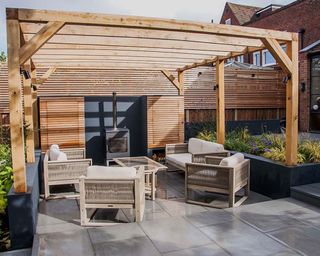 paved patio with woodburning stove and timber pergola