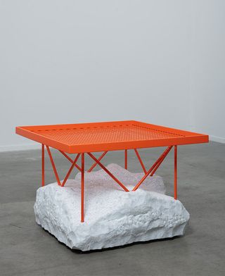 Bright orange table with white stone base designed by Samuel Ross