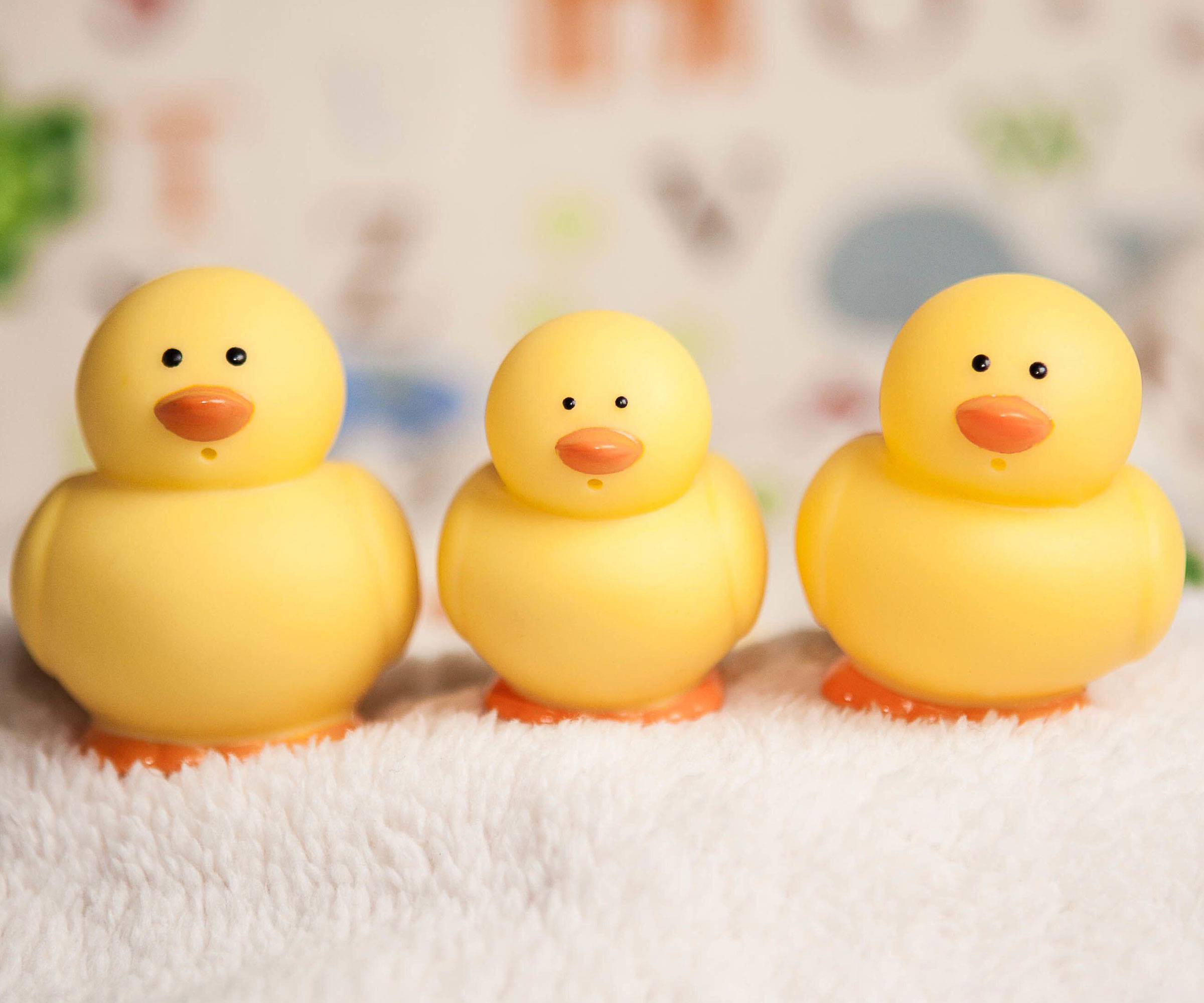 yellow rubber ducks sitting on white towel
