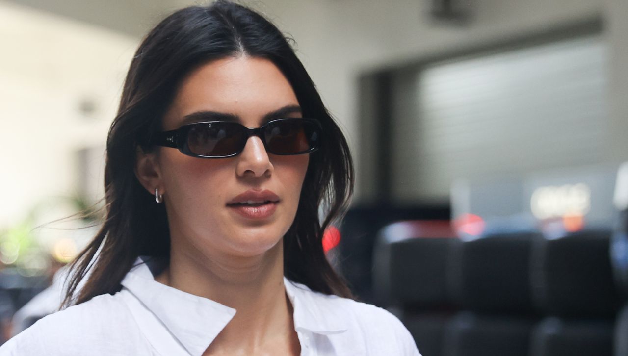 Kendall Jenner wears a white button down shirt with sunglasses in an example of mixing neutrals