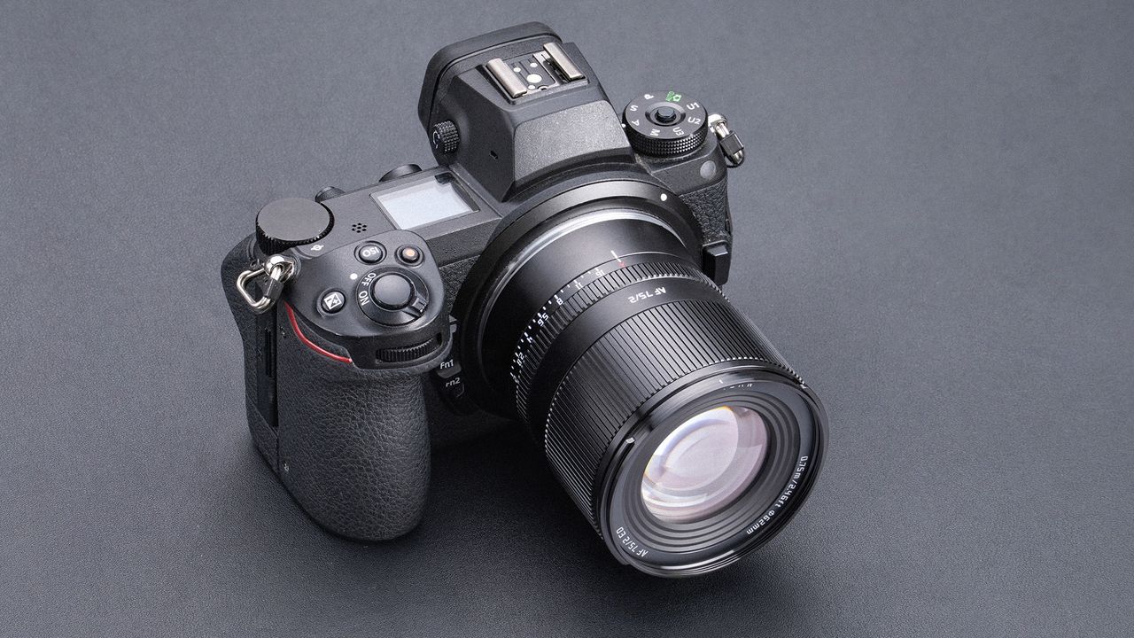 TTArtisan AF 75mm f/2 attached to a mirrorless camera, on a grey surface