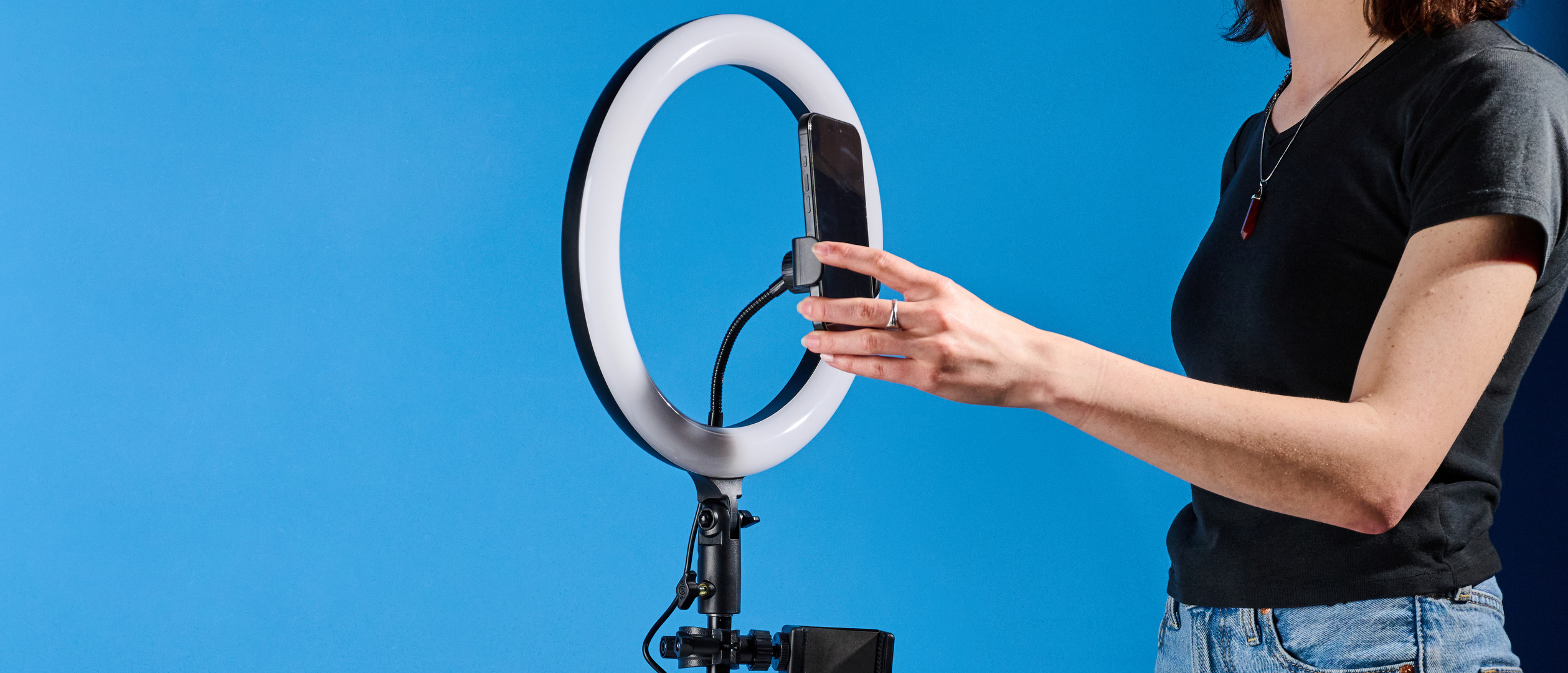 Godox 12-inch ring light photographed in front of a blue background with an iPhone on the phone mount. 