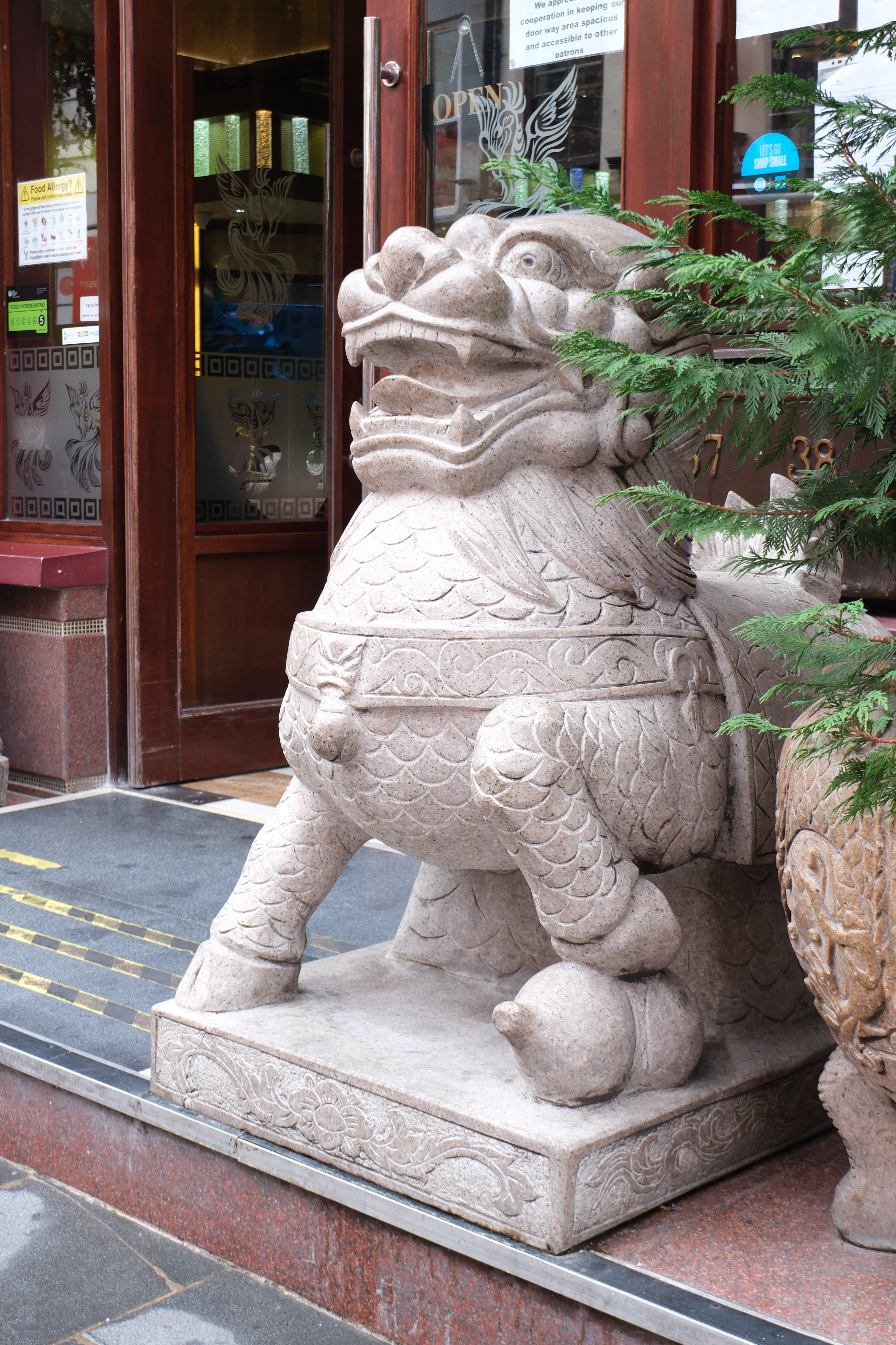 A statue of a Chinese dragon outside of a restaurant