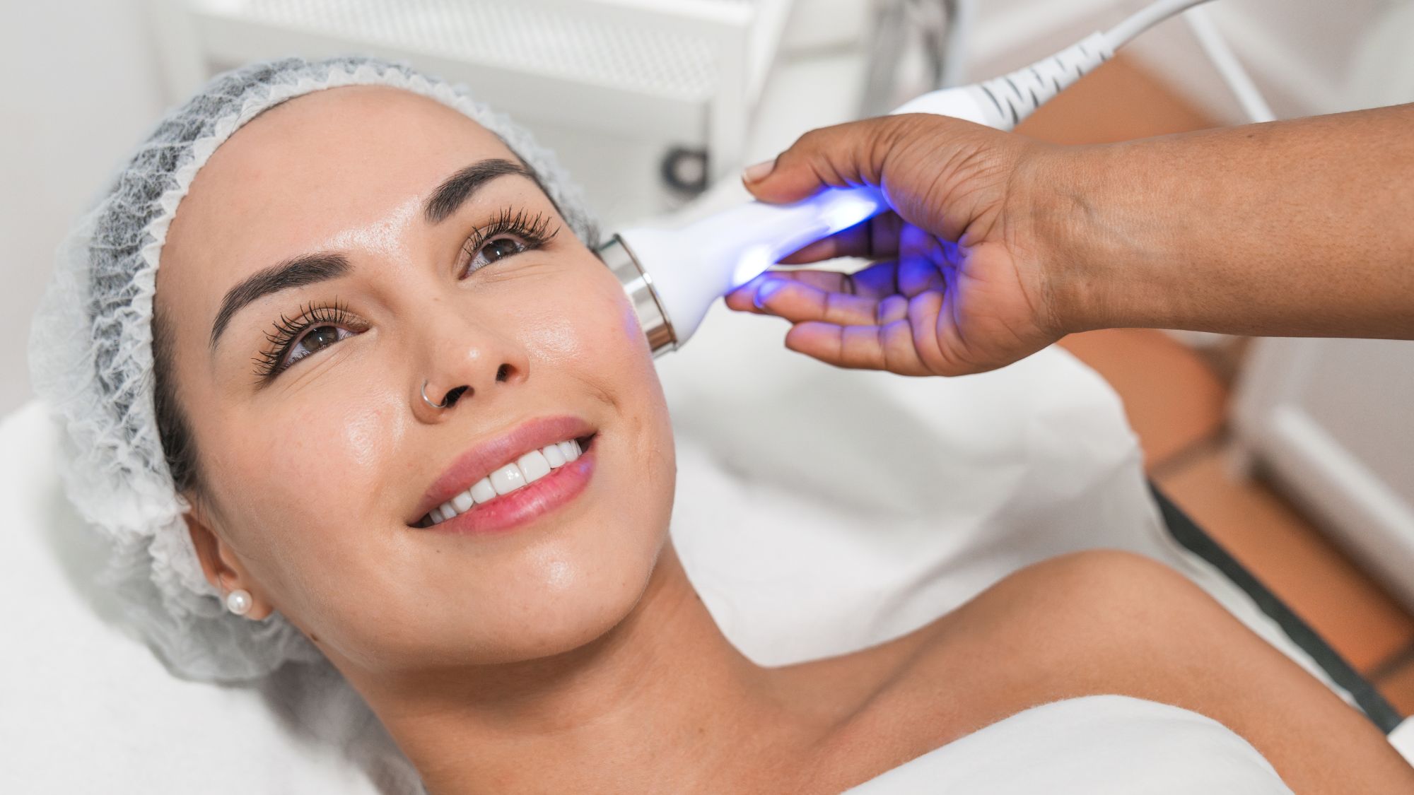 woman on a clinic bed getting a facial laser treatment