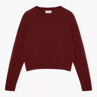 A cut out of a burgundy Brora crew neck jumper against a white background