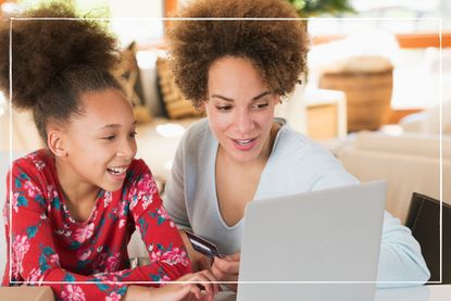 Mother and daughter looking at laptop while at home