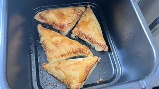 Cooked apple turnovers in an air fryer drawer