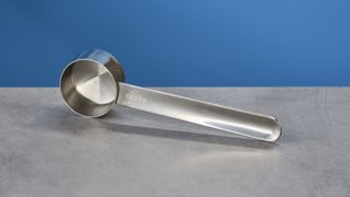 a silver aarke branded scoop with a 7.5 oz capacity for scooping coffee into the Aarke Coffee Maker