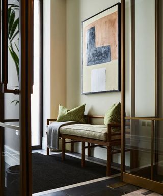 Small entryway with wooden bench and artwork hung above