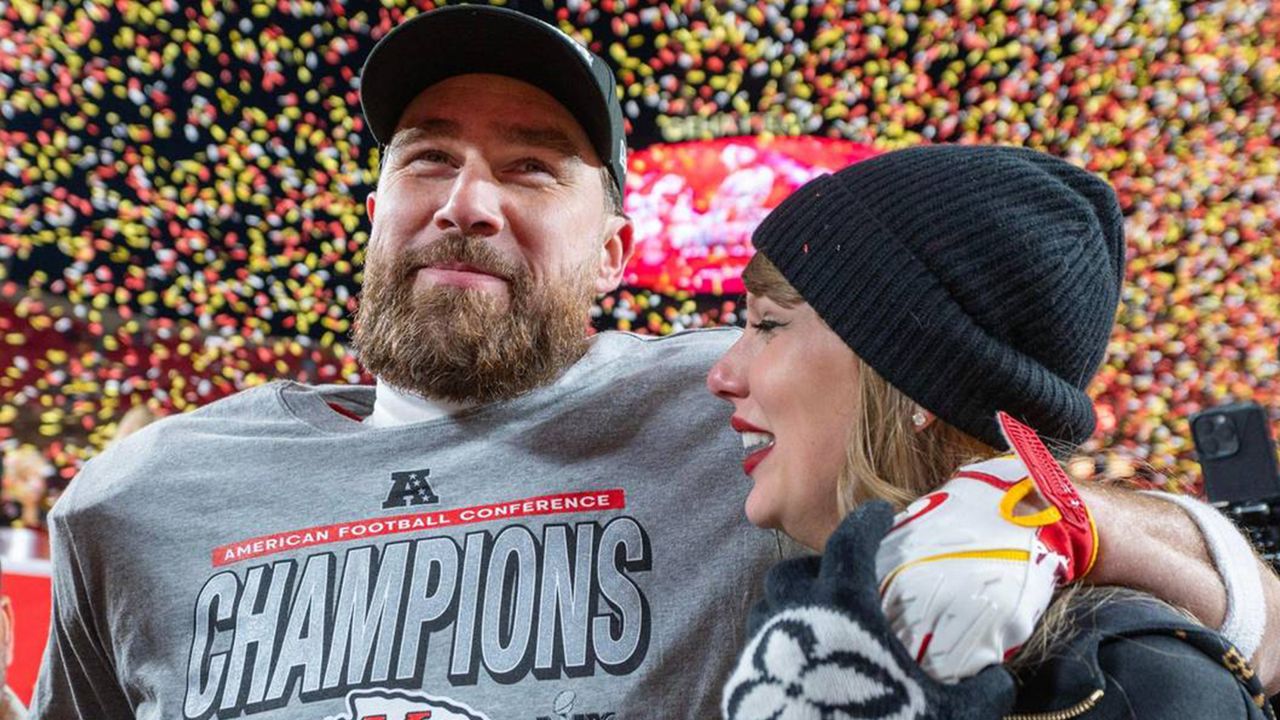 Travis Kelce wearing a gray t-shirt putting his arm around Taylor Swift with confetti falling behind them at the AFC Championships 2025