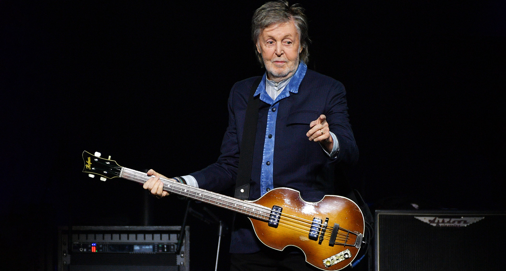 Paul McCartney points to the crowd and raises an eyebrow as he performs with his iconic H&ouml;fner Violin Bass