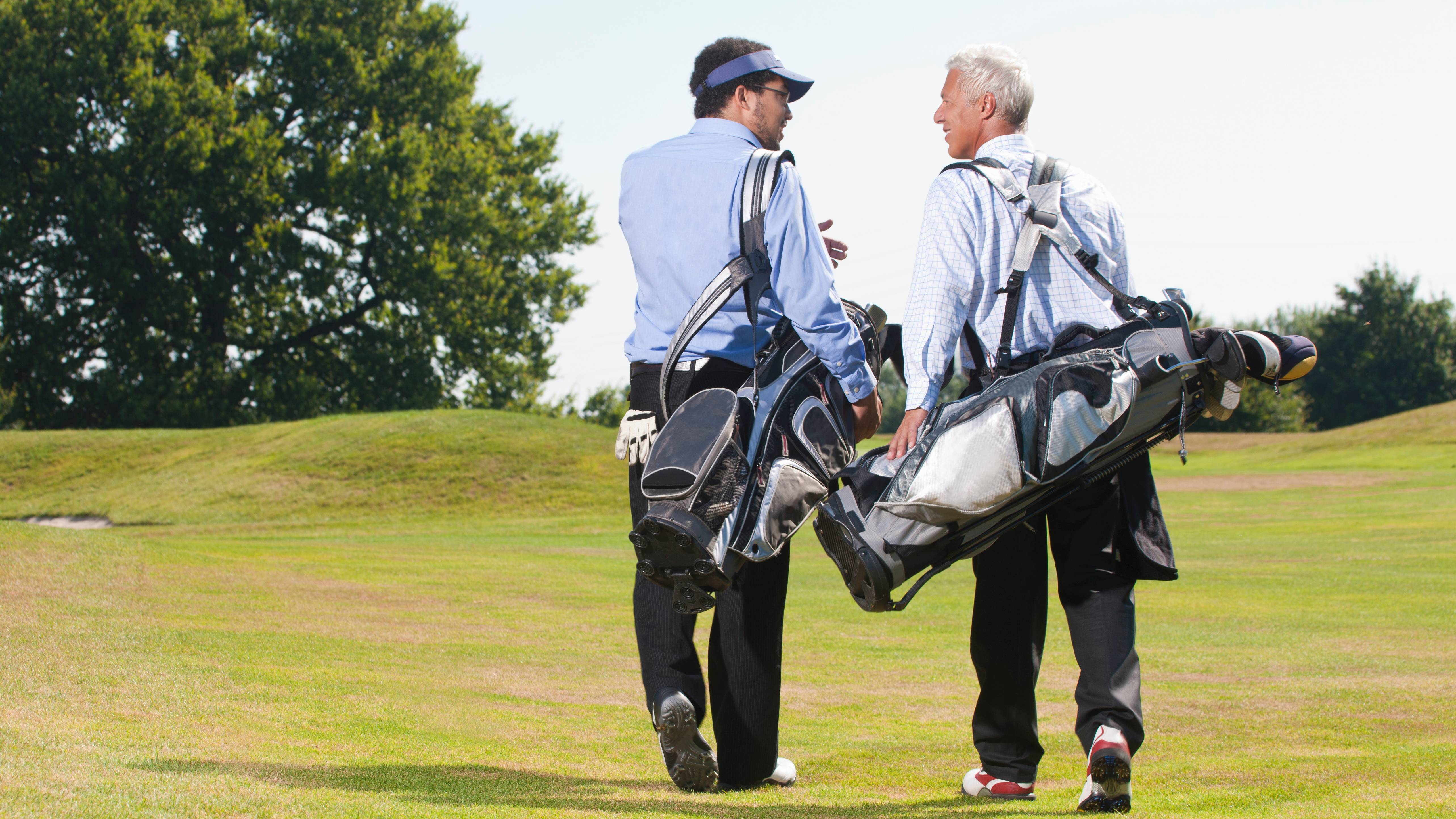 Two male golfers walking along the fairway