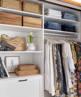 Walk-in closet with wooden storage boxes and hanging rails