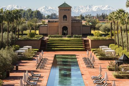 A view of the Selman Marrakech Hotel with the Atlas Mountains looming in the background.