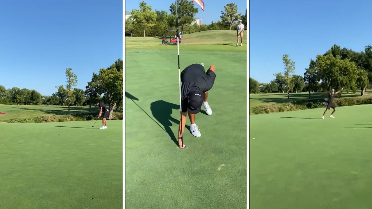 A golfer holing a putt and picking a golf ball out a hole