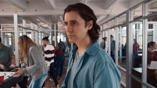 Jared Leto as Adam Neumann, standing in an office, in WeCrashed