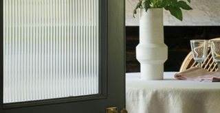 glass panel door painted dark with reeded film to show how to make a kitchen look expensive on a budget