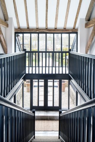 atrium entrance with black stair rails and white walls with beams